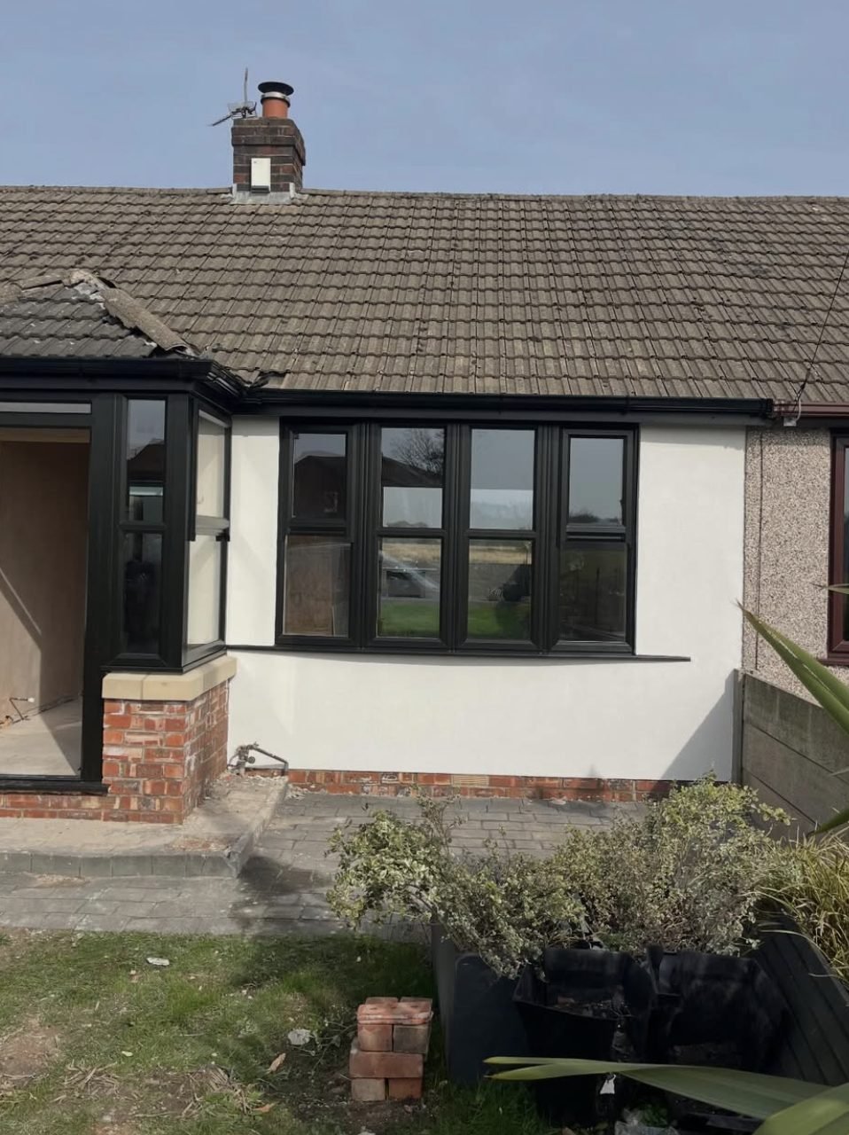 Bungalow front in a smooth white finish beside pebbledash next door