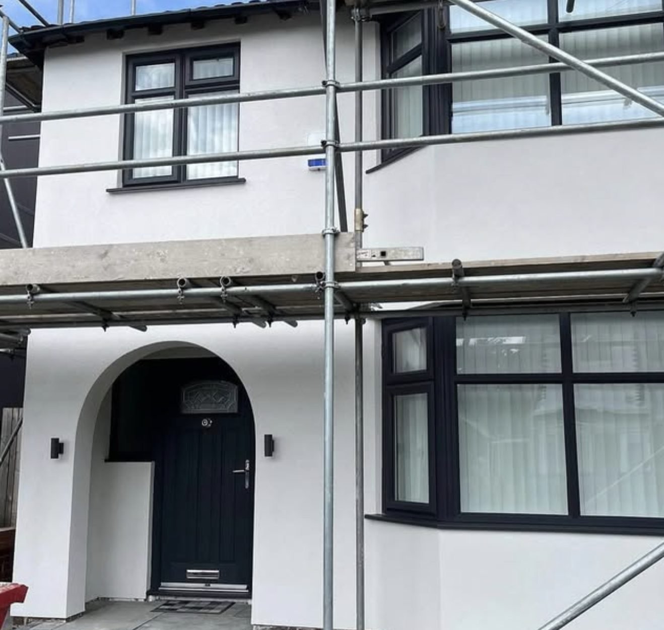 Semi-detached house in a fresh white finish with scaffolding still up