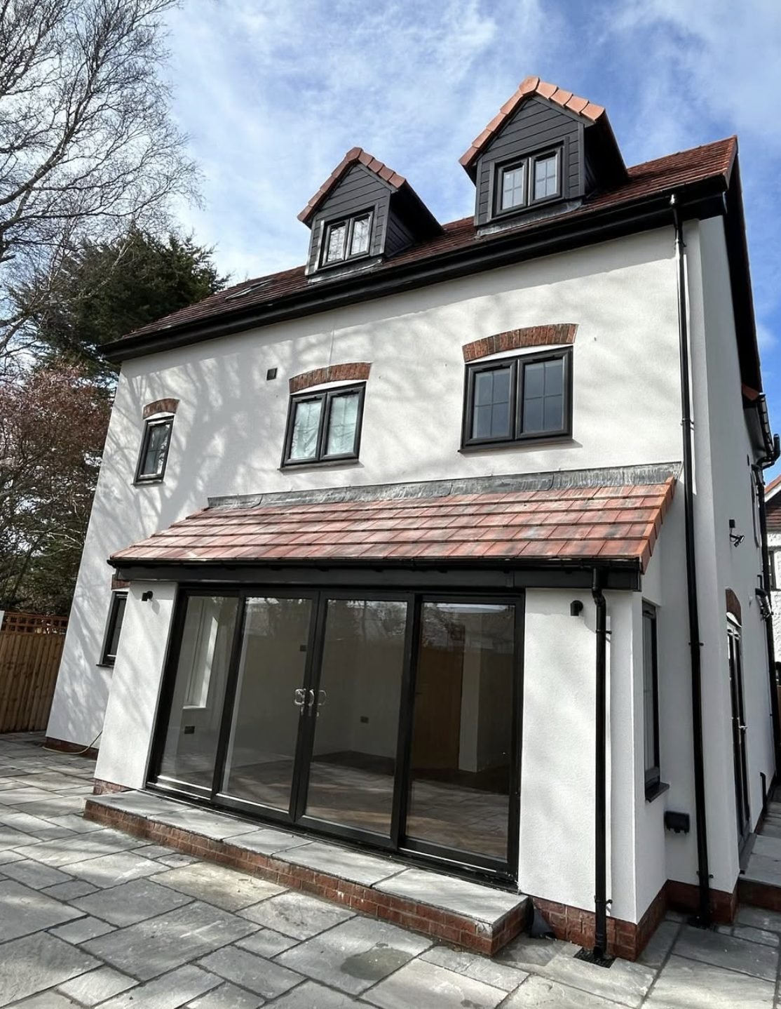 Three-storey rear elevation in white with dormers and a single-storey extension
